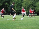 The men's soccer team practicing in red jerseys.